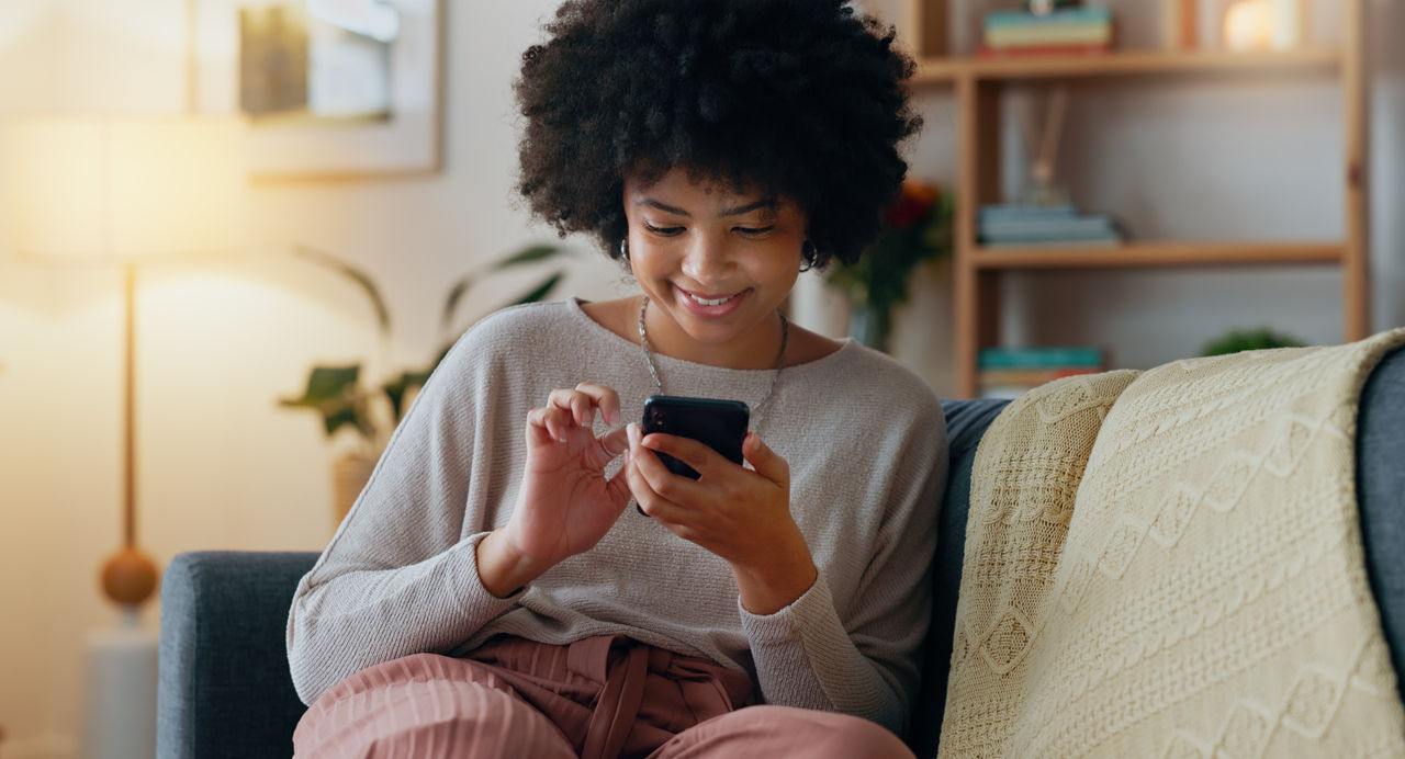 Girl on couch using her mobile phone. 
