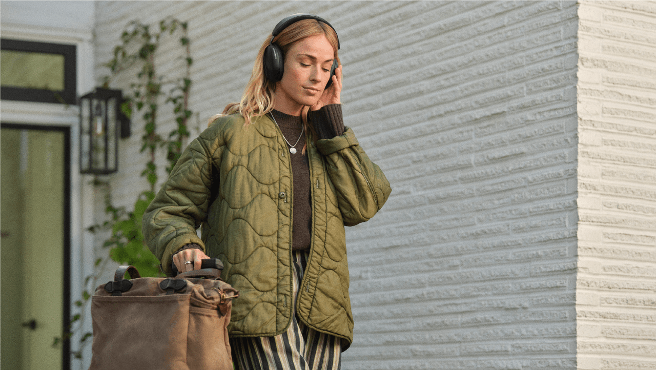 person walking out of home with headphones on