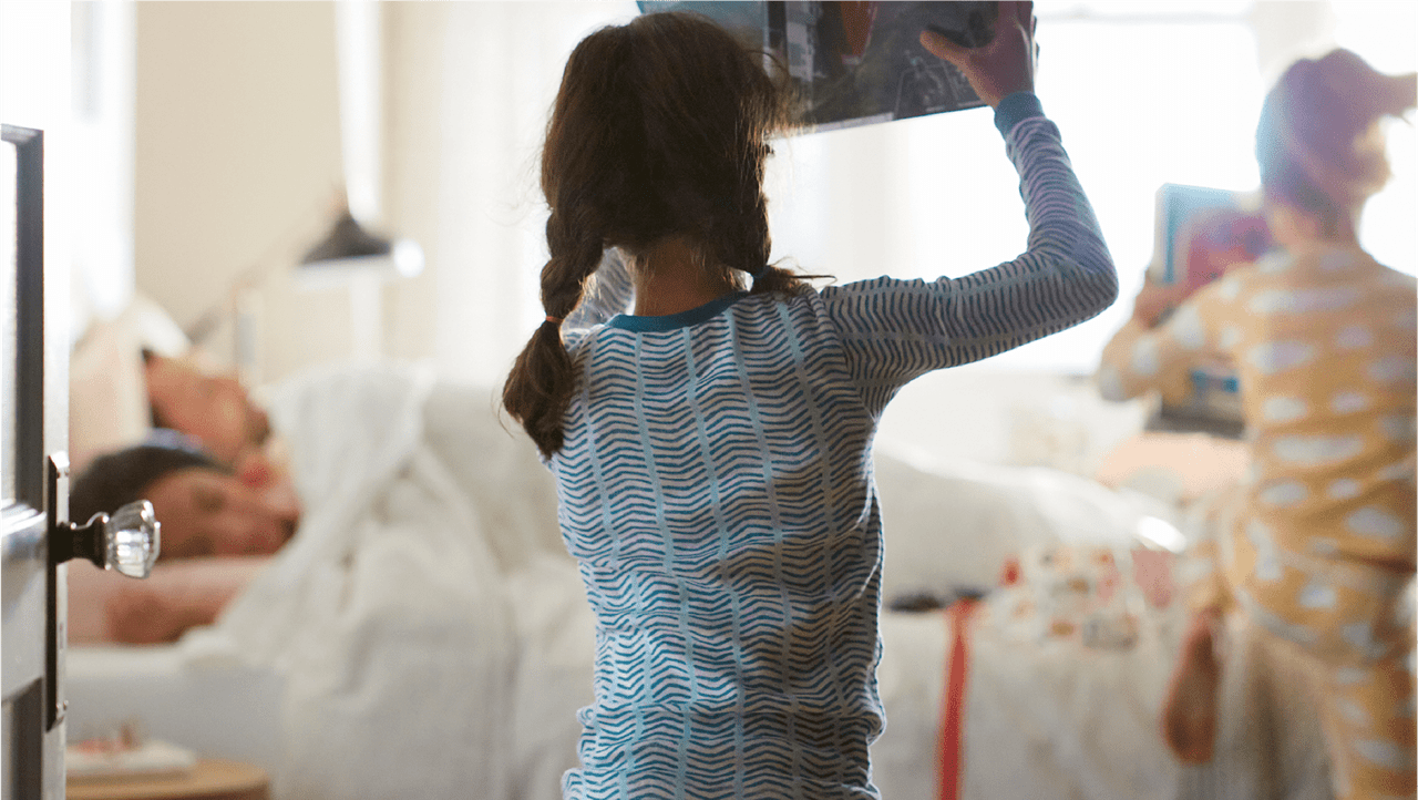 image of children happily running to parents bed