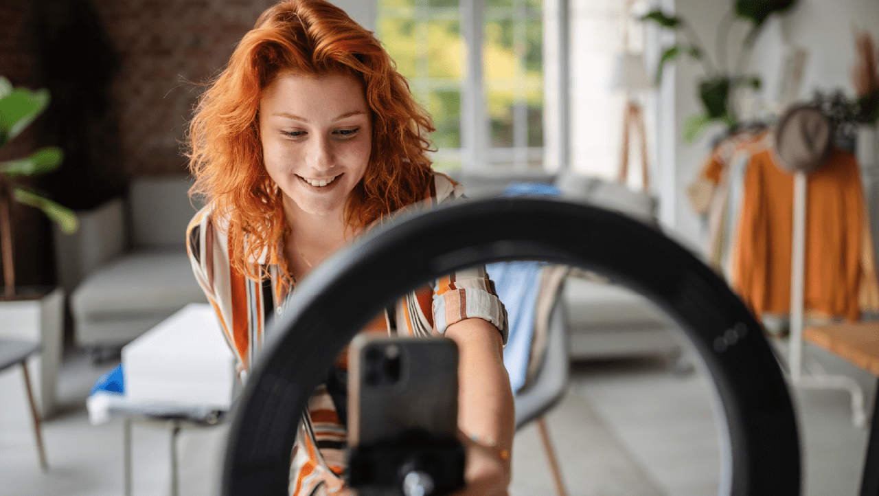person filming themselves with a mobile phone and ring light