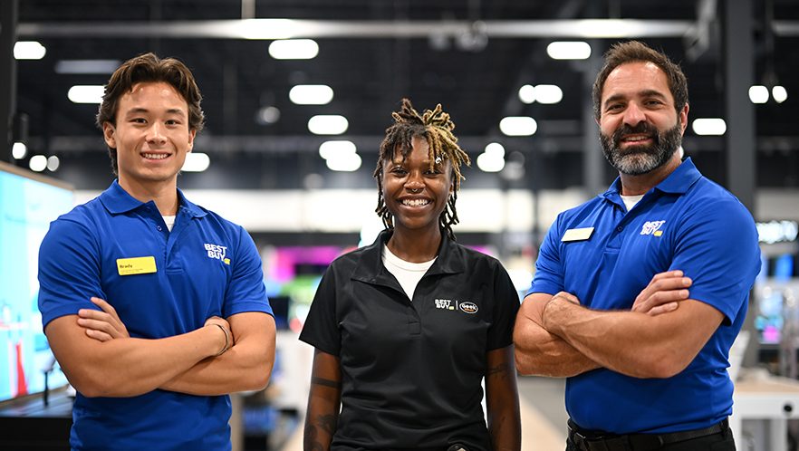 Best Buy employees standing with a Geek Squad Agent.